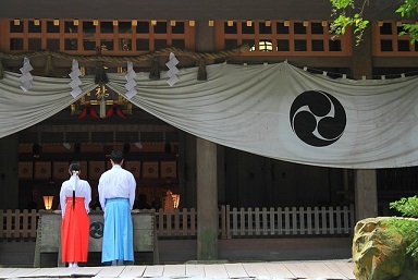 巫女と神主が神社で祈っている