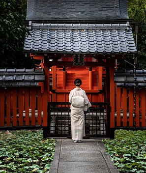 神社のまえで立っている女性